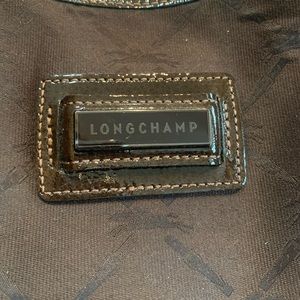 Brown cloth bag with patent brown trim. Traditional Longchamp horse pattern.